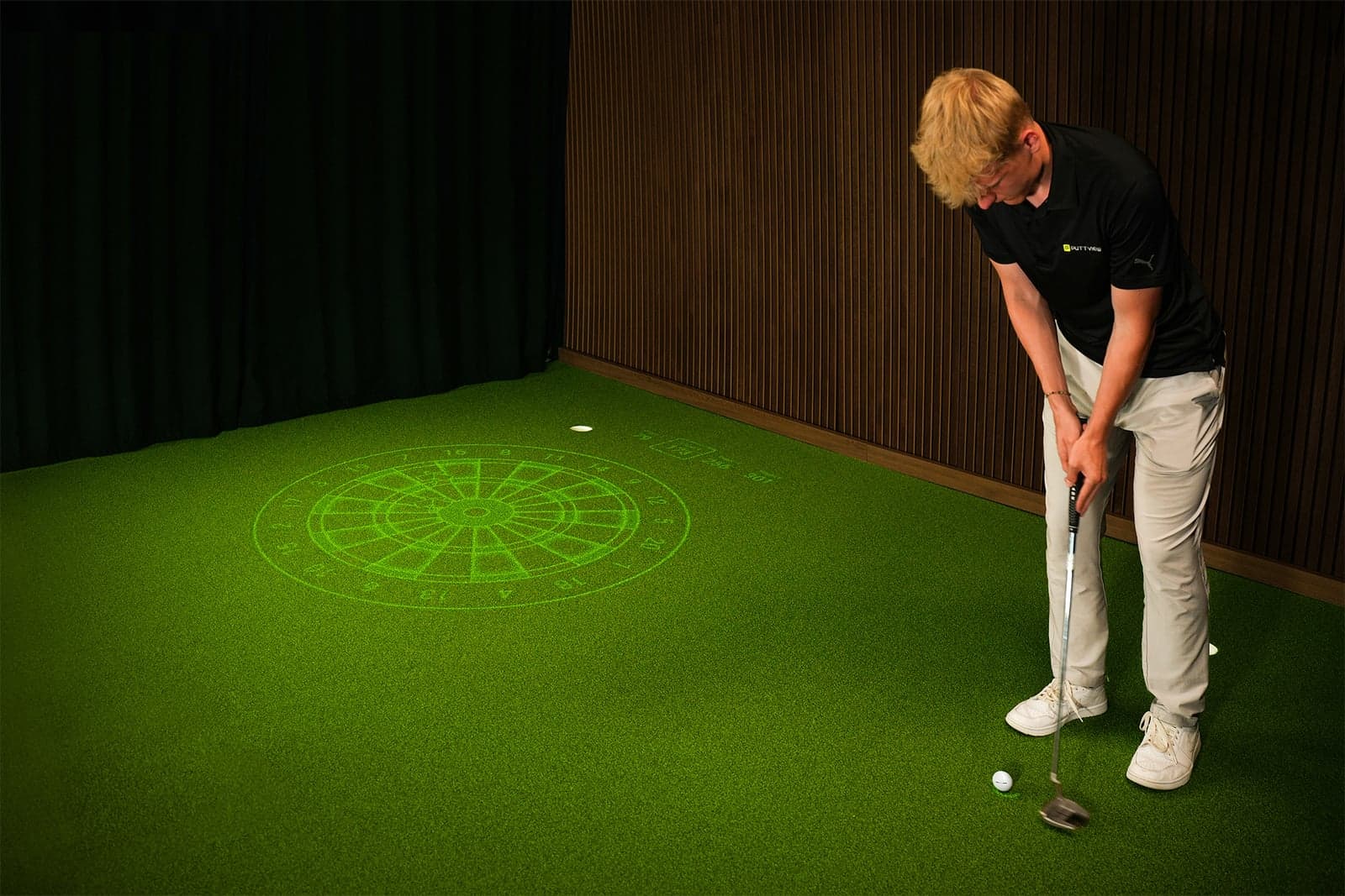 PuttView DARTS target projected onto an indoor putting green, golfer putting